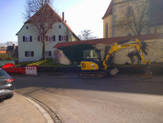 Baustelle mit Bagger und Archäologin