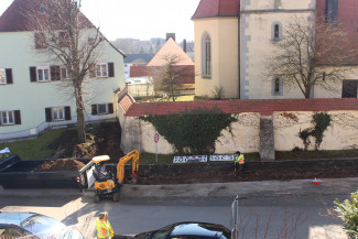 Baustelle mit Bagger, Archäologin bei Ausgrabung