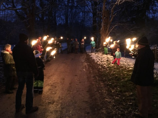 Gruppe im Schnee mit Fackeln 